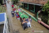 Warga membawa jenazah melewati genangan banjir di Bojongasih, Kabupaten Bandung, Jawa Barat, Kamis (19/12/2019). Banjir yang melanda sedikitnya lima kecamatan di Kabupaten Bandung tersebut mulai surut meskipun warga masih khawatir akan banjir susulan akibat kembali meluapnya Sungai Citarum dan intensitas curah hujan yang tinggi. ANTARA JABAR/Novrian Arbi/agr