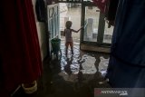 Seorang anak membersihkan rumah yang terdampak banjir di Bojongasih, Kabupaten Bandung, Jawa Barat, Kamis (19/12/2019). Banjir yang melanda sedikitnya lima kecamatan di Kabupaten Bandung tersebut mulai surut meskipun warga masih khawatir akan banjir susulan akibat kembali meluapnya Sungai Citarum dan intensitas curah hujan yang tinggi. ANTARA JABAR/Novrian Arbi/agr