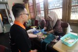 Seorang warga menjalani proses donor darah yang dilakukan petugas PMI Pontianak di Kantor LKBN Antara Biro Kalbar di Pontianak, Kamis (19/12/2019). Kegiatan tersebut merupakan rangkaian kegiatan dari peringatan HUT ke-82 LKBN Antara. ANTARA FOTO/Jessica Helena Wuysang.