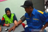 Petugas melakukan pemeriksaan tekanan darah sopir bus di terminal Kepuhsari Jombang, Jawa Timur, Kamis (19/12/2019). Pemeriksaan kesehatan sopir bus meliputi, gula darah, alkohol, tekanan darah dan narkoba itu untuk menjamin keselamatan penumpang angkutan umum jelang libur Natal dan Tahun Baru. Antara Jatim/Syaiful Arif/zk