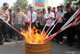 Polisi bersama sejumlah elemen masyarakat membakar pil koplo hasil Operasi Aman Semeru 2019 di Polresta Kediri, Jawa Timur, Kamis (19/12/2019). Pemusnahan barang bukti pil koplo dan minuman keras itu merupakan hasil operasi selama dua minggu guna menjaga suasana kondusif menjelang Natal dan Tahun Baru. Antara Jatim/Prasetia Fauzani/zk