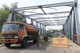 Truk melewati jembatan Keras di jalan raya Kediri -Tulungagung di Desa Ringinrejo, Kediri, Jawa Timur, Jumat (20/12/2019). Jembatan di jalur utama Kediri - Tulungagung yang dibangun pada tahun 1991 tersebut rusak dan ditutup sebagian untuk menghindari kejadian yang tidak diinginkan. Antara Jatim/Prasetia Fauzani/zk