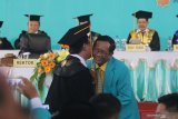 Menko Polhukam Mahfud MD (kanan) berjabat tangan dengan rektor Universitas Islam Kadiri (Uniska) Prof Ali Maschan Moesa (kiri) usai menyampaikan orasi ilmiah saat acara wisuda Uniska di Kota Kediri, Jawa Timur, Sabtu (21/12/2019). Mahfud MD dalam orasi ilmiahnya menyatakan pentingnya agama dalam membentuk moralitas dan penyeimbang ilmu pengetahuan. Antara Jatim/Prasetia Fauzani/zk.