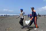 Anggota polisi dan siswa SMK Perikanan dan Kelautan Puger mengambil sampah plastik di Pantai Pancer, Puger, Jember, Jawa Timur, Sabtu (21/12/2019). Kegiatan mendaur ulang sampah plastik menjadi BBM setara solar dan premium dilakukan bersamaan dengan kegiatan bersih-bersih sampah plastik dalam rangka peduli lingkungan. Antara Jatim/Seno/zk.