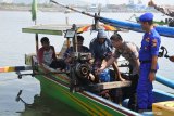 Kapolres Jember AKBP Alfian Nurrizal (kedua kanan), di dampingi nelayan menghidupakan mesin perahu setelah mengisi Bahan Bakar Minyak (BBM) solar hasil daur ulang sampah plastik di Pantai Pancer, Puger, Jember, Jawa Timur, Sabtu (21/12/2019).  Kegiatan mendaur ulang sampah plastik menjadi BBM setara solar dan premium dilakukan bersamaan dengan kegiatan bersih-bersih sampah plastik dalam rangka peduli lingkungan. Antara Jatim/Seno/zk.