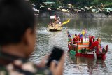 Warga menyaksikan festival Perahu Nusantara di Sungai Kalimas, Surabaya, Jawa Timur, Minggu (22/12/2019). Kegiatan itu merupakan salah satu rangkaian acara untuk memeriahkan HUT ke-71 Kodam V/Brawijaya. Antara Jatim/Didik/ZK