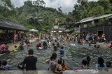 Pengunjung menikmati wahana permainan air di Kawasan wisata Gunung Galunggung, Kabupaten Tasikmalaya, Jawa Barat, Minggu (22/12/2019). Pengunjung yang didominasi anak-anak sekolah memanfaatkan hari liburnya untuk mengunjungi kawasan wisata Gunung Galunggung yang menyediakan pemandian air panas. ANTARA JABAR/Adeng Bustomi/agr