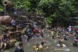 Pengunjung menikmati wahana permainan air di Kawasan wisata Gunung Galunggung, Kabupaten Tasikmalaya, Jawa Barat, Minggu (22/12/2019). Pengunjung yang didominasi anak-anak sekolah memanfaatkan hari liburnya untuk mengunjungi kawasan wisata Gunung Galunggung yang menyediakan pemandian air panas. ANTARA JABAR/Adeng Bustomi/agr