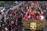 Para pemain dan ofisial tim Bali United menyapa pendukungnya dari atas mobil hias saat mengikuti Parade Juara Liga 1 2019 di kawasan Gianyar, Bali, Senin (23/12/2019). Parade Juara dari kawasan Lapangan Puputan Badung Kota Denpasar menuju Stadion Kapten I Wayan Dipta Kabupaten Gianyar diikuti oleh ribuan pendukung Bali United untuk merayakan keberhasilan tim Bali United menjadi Juara Liga 1 2019. ANTARA FOTO/Fikri Yusuf/nym