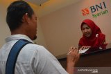 Petugas teller bank melayanai nasabah usai peresmian kantor cabang pembantu (KCP) BNI Syariah Jombang, Jawa Timur, Senin (23/12/2019). Dengan dibukanya kantor cabang pembantu BNI Syariah di wilayah Kabupaten Jombang itu agar dapat mendekatkan masyarakat untuk menjangkau akses permodalan, simpanan dana maupun produk perencanaan syariah. Antara Jatim/Syaiful Arif/zk