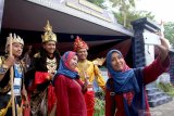 Warga berswafoto dengan petugas berpakaian ala kerajaan majapahit yang berjaga di depan Pos Pengamanan (PAM) Natal dan Tahun Baru (NATARU) 2019/2020 di jalan raya Wlingi, Blitar, Jawa Timur, Senin (23/12/2019). Selain bertujuan untuk menjaga keamanan warga dan pengguna jalan selama masa Operasi Lilin Semeru 2019, Pos PAM milik Polres Blitar tersebut sengaja mengangkat tema Candi Penataran guna mempromosikan kawasan wisata yang merupakan ikon daerah itu, serta bertujuan untuk memberikan edukasi sejarah kepada masyarakat. Antara Jatim/Irfan Anshori/zk.