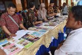 Pengunjung memilih buku di stan pameran saat Simposium Gerakan Literasi Nasional (GLN) di Pendopo Ronggo Djoemeno, Kabupaten Madiun, Jawa Timur, Minggu (22/12/2019). Simposium bertema 