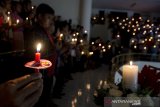 Jemaat menyalakan lilin saat mengikuti kebaktian malam Natal 2019 di GKI Kawasan Maulana Yusuf, Bandung, Jawa Barat, Selasa (24/12/2019) malam. Misa dengan tema 