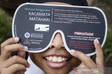 Pelajar menggunakan kacamata matahari saat menyaksikan gerhana matahari sebagian di Lapangan Sinapeul, Bosscha Observatory, Lembang, Kabupaten Bandung Barat, Jawa Barat, Kamis (26/12/2019). Wilayah Jawa Barat hanya bisa menyaksikan gerhana matahari sebagian saat terjadinya fenomena gerhana matahari cincin yang melintasi sejumlah daerah di Indonesia yang berlangsung sekitar tiga jam. ANTARA JABAR/Novrian Arbi/agr