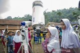 Pelajar menggunakan teleskop atau teropong bintang saat menyaksikan gerhana matahari sebagian di Lapangan Sinapeul, Bosscha Observatory, Lembang, Kabupaten Bandung Barat, Jawa Barat, Kamis (26/12/2019). Wilayah Jawa Barat hanya bisa menyaksikan gerhana matahari sebagian saat terjadinya fenomena gerhana matahari cincin yang melintasi sejumlah daerah di Indonesia yang berlangsung sekitar tiga jam. ANTARA JABAR/Novrian Arbi/agr