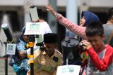 Warga melihat matahari dengan menggunakan teropong di Masjid Al Akbar Surabaya, Jawa Timur, Kamis (26/12/2019). Gerhana Matahari Cincin yang terjadi di sejumlah daerah dapat dilihat sebagian (parsial) di wilayah Surabaya. Antara Jatim/Didik/ZK