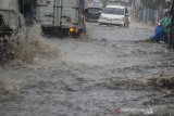 Sejumlah kendaraan melintasi derasnya arus air saat hujan deras di kawasan Cikutra, Bandung, Jawa Barat, Jumat (27/12/2019). Genangan air terjadi akibat tingginya intensitas hujan dan buruknya drainase di kawasan tersebut. ANTARA JABAR/Novrian Arbi/agr