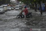 Pengendara menerjang genangan air  yang menggenangi jalan Jakarta di Bandung, Jawa Barat, Jumat (27/12/2019). Genangan setinggi 30 hingga 50 sentimeter tersebut disebabkan sistem drainase yang buruk dan intensitas hujan tinggi di kota Bandung. ANTARA JABAR/Raisan Al Farisi/agr
