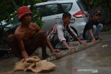 Warga menunjukkan ular piton yang ditemukan di Desa Tondowulan, Kecamatan Plandaan, Kabupaten Jombang, Jawa Timur, Jumat (27/12/2019). Ular piton dengan panjang sekitar 4 meter dan berat 50 kilogram itu ditemukan warga di sungai sekitar usai memangsa kucing pada Kamis (26/12/2019) malam. Antara Jatim/Syaiful Arif/zk.