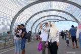 Wisatawan swa foto di jembatan lintas di Marina Boom, Banyuwangi, Jawa Timur, Sabtu (28/12/2019). Jembatan berbentuk oval yang menjadi tempat favorit untuk berfoto itu, menjadi alternatif wisatawan saat menghabiskan masa libur Natal dan Tahun baru 2020 di Banyuwangi. Antara Jatim/Budi Candra Setya/zk