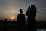 Pengunjung melakukan swafoto saat fajar pertama tahun 2020 di jembatan Kampung Warna-warni Jodipan dengan berlatar belakang gunung Semeru di  Malang, Jawa Timur, Rabu (1/1/2020). Setelah merayakan malam pergantian tahun, sejumlah wisatawan sengaja datang ke kawasan wisata tersebut untuk melihat matahari terbit pertama tahun 2020. Antara Jatim/Ari Bowo Sucipto/zk