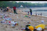 Petugas membersihkan sampah sisa perayaan tahun baru yang dibuang sembarangan di Pantai Kuta, Badung, Bali, Rabu (1/1/2020). Pantai Kuta dipenuhi sampah bekas kembang api dan sampah plastik bekas makanan atau minuman yang berserakan pascaperayaan pergantian tahun baru. ANTARA FOTO/Nyoman Hendra Wibowo/nym.