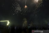 Warga menyaksikan  kembang api yang dinyalakan pada malam pergantian tahun di Lapangan Gasibu, Bandung, Jawa Barat, Kamis (1/1/2020). Lapangan Gasibu menjadi salah satu kawasan bagi warga Kota Bandung untuk menikmati pergantian tahun 2019 ke tahun 2020. ANTARA JABAR/Novrian Arbi/agr