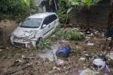 Warga melihat kondisi mobil yang rusak pascaterseret banjir bandang di Cimareme, Kabupaten Bandung Barat, Jawa Barat, Kamis (1/1/2020). Puluhan rumah warga di Komplek Cimareme Indah tersebut rusak diterjang banjir akibat jebolnya tanggul sungai irigasi dan intensitas curah hujan yang tinggi yang terjadi pada rabu (31/12/2019) lalu. ANTARA  JABAR/Novrian Arbi/agr