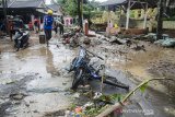 Petugas bersama warga membersihkan sisa lumpur pascabanjir bandang di Cimareme, Kabupaten Bandung Barat, Jawa Barat, Kamis (1/1/2020). Puluhan rumah warga di Komplek Cimareme Indah tersebut rusak diterjang banjir akibat jebolnya tanggul sungai irigasi dan intensitas curah hujan yang tinggi yang terjadi pada rabu (31/12/2019) lalu. ANTARA JABAR/Novrian Arbi/agr