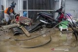 Warga membersihkan sisa lumpur pascabanjir bandang di Cimareme, Kabupaten Bandung Barat, Jawa Barat, Kamis (1/1/2020). Puluhan rumah warga di Komplek Cimareme Indah tersebut rusak diterjang banjir akibat jebolnya tanggul sungai irigasi dan intensitas curah hujan yang tinggi yang terjadi pada rabu (31/12/2019) lalu. ANTARA JABAR/Novrian Arbi/agr