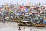 Nelayan berada di sekitar perahu mereka yang bersandar di pantai Dadap, Indramayu, Jawa Barat, Jumat (3/1/2020). Sejak dua pekan terakhir nelayan daerah tersebut tidak melaut akibat angin kencang dan gelombang tinggi. ANTARA JABAR/Dedhez Anggara/agr