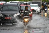 Pengendara melintas di genangan air di Jalan Ahmad Yani, Banjarmasin, Kalimantan Selatan, Sabtu (4/1/2020). Intensitas hujan yang cukup tinggi melanda Kota Banjarmasin mengakibatkan sejumlah jalan raya tergenang air yang mengganggu pengguna jalan. Foto Antaranews Kalsel/Bayu Pratama S.