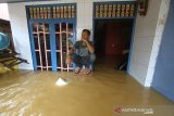 Warga beraktivitas saat banjir di kawasan Cempaka, Banjarbaru, Kalimantan Selatan, Minggu (5/1/2020). Banjir yang disebabkan meluapnya sungai Tiung di kawasan Cempaka tersebut berdasarkan data Badan Penanggulangan Bencana Daerah (BPBD) Kalsel mengakibatkan 70 rumah dan tiga sekolah PAUD terendam. Foto Antaranews Kalsel/Bayu Pratama S.