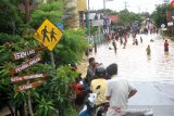 Warga beraktivitas saat banjir di kawasan Cempaka, Banjarbaru, Kalimantan Selatan, Minggu (5/1/2020). Banjir yang disebabkan meluapnya sungai Tiung di kawasan Cempaka tersebut berdasarkan data Badan Penanggulangan Bencana Daerah (BPBD) Kalsel mengakibatkan 70 rumah dan tiga sekolah PAUD terendam. Foto Antaranews Kalsel/Bayu Pratama S.