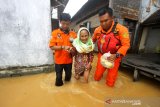 Petugas Badan Pencarian dan Pertolongan Nasional (BASARNAS) Banjarmasin membantu warga melintasi banjir di kawasan Cempaka, Banjarbaru, Kalimantan Selatan, Minggu (5/1/2020). Banjir yang disebabkan meluapnya sungai Tiung di kawasan Cempaka tersebut berdasarkan data Badan Penanggulangan Bencana Daerah (BPBD) Kalsel mengakibatkan 70 rumah dan tiga sekolah PAUD terendam. Foto Antaranews Kalsel/Bayu Pratama S.