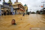 Anak-anak bermain air saat banjir di kawasan Cempaka, Banjarbaru, Kalimantan Selatan, Minggu (5/1/2020). Banjir yang disebabkan meluapnya sungai Tiung di kawasan Cempaka tersebut berdasarkan data Badan Penanggulangan Bencana Daerah (BPBD) Kalsel mengakibatkan 70 rumah dan tiga sekolah PAUD terendam. Foto Antaranews Kalsel/Bayu Pratama S.