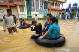 Anak-anak bermain air saat banjir di kawasan Cempaka, Banjarbaru, Kalimantan Selatan, Minggu (5/1/2020). Banjir yang disebabkan meluapnya sungai Tiung di kawasan Cempaka tersebut berdasarkan data Badan Penanggulangan Bencana Daerah (BPBD) Kalsel mengakibatkan 70 rumah dan tiga sekolah PAUD terendam. Foto Antaranews Kalsel/Bayu Pratama S.