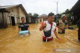 Petugas dari Dinas Kesehatan Provinsi Kalsel mendatangi warga saat banjir di kawasan Cempaka, Banjarbaru, Kalimantan Selatan, Minggu (5/1/2020). Dinas Kesehatan Provinsi Kalsel langsung memberikan pertolongan pertama kepada warga yang terdampak banjir di kawasan cempaka yang disebabkan meluapnya sungai Tiung di daerah setempat. Foto Antaranews Kalsel/Bayu Pratama S.