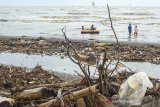 Sejumlah anak bermain disekitar tumpukan sampah yang tersebar di Pantai Sedari, Karawang, Jawa Barat, Minggu (5/1/2020). Keberadaan sampah yang mencemari kawasan pantai tersebut diduga kiriman dari hulu yang terbawa arus sehingga menggangu keindahan dan kenyamanan pengunjung serta berdampak buruk pada ekosistem laut. ANTARA JABAR/M Ibnu Chazar/agr