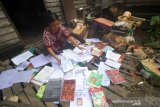 Seorang warga menjemur buku pelajaran pasca banjir di Kecamatan Cempaka, Banjarbaru, Kalimantan Selatan, Senin (6/1/2020). Warga mulai membenahi barang-barang rumah tangga serta membersihkan rumah pasca banjir yang melanda kawasan tersebut. Foto Antaranews Kalsel/Bayu Pratama S.