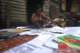 Seorang warga menjemur buku pelajaran pasca banjir di Kecamatan Cempaka, Banjarbaru, Kalimantan Selatan, Senin (6/1/2020). Warga mulai membenahi barang-barang rumah tangga serta membersihkan rumah pasca banjir yang melanda kawasan tersebut. Foto Antaranews Kalsel/Bayu Pratama S.