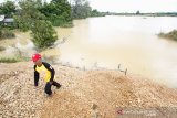 Seorang warga berada di penambangan intan tradisional yang terendam air di desa Pumpung ,kecamatan Cempaka, Banjarbaru, Kalimantan Selatan, Selasa (7/1/2020). Tempat penambangan intan tradisional terendam air yang disebabkan meluapnya sungai Basung di kawasan tersebut mengakibatkan warga tidak dapat bekerja melenggang intan. Foto Antaranews Kalsel/Bayu Pratama S.