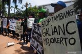 Sejumlah pengunjuk rasa yang tergabung dalam Aliansi Masyarakat Peduli Lingkungan membentangkan poster saat aksi 'stop tambang galian C di Mojokerto' di depan Kantor Gubernur Jawa Timur, Surabaya, Jawa Timur, Selasa (7/1/2020). Dalam aksinya mereka menyerukan agar Pemprov Jatim segera mencabut izin operasi tambang gaian C di Desa Lebak Jabung karena berpotensi merusak lingkungan. Antara Jatim/Zabur Karuru