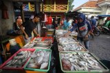 Pedagang ikan melayani pembeli di salah satu stan di Pasar Pabean, Surabaya, Jawa Timur, Selasa (7/1/2020). Menurut para pedagang harga sejumlah ikan laut naik antara Rp2.000 hingga Rp15.000 per kilogram dari harga sebelumnya karena dipicu kurangnya pasokan ikan dari nelayan akibat cuaca buruk yang terjadi dalam sepekan terakhir. Antara Jatim/Moch Asim/zk.