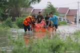 Petugas BPBD mengevakuasi warga saat terjadi banjir di Desa Guranganyar, Kecamatan Cerme, Gresik, Jawa Timur, Rabu (8/1/2020). Delapan desa di kecamatan tersebut terendam banjir akibat luapan air Kali Lamong. Antara Jatim/Moch Asim/zk.