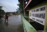 Warga berjalan di tengah banjir di Desa Guranganyar, Kecamatan Cerme, Gresik, Jawa Timur, Rabu (8/1/2020). Delapan desa di kecamatan tersebut terendam banjir akibat luapan air Kali Lamong. Antara Jatim/Moch Asim/zk.