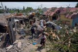 Warga mencari barang-barang yang masih bisa diselamatkan setelah sebuah pohon menimpa rumah warga di Denpasar, Bali, Rabu (8/1/2020). Musibah pohon tumbang tersebut menyebabkan tiga warga luka-luka, dua rumah rusak berat dan tiga rumah lainnya rusak ringan. ANTARA FOTO/Nyoman Hendra Wibowo/nym