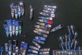 Foto udara sejumlah kapal nelayan bersandar di Pelabuhan Perikanan Cikidang, Kabupaten Pangandaran, Jawa Barat, Rabu (8/1/2020). Sebagian nelayan di daerah tersebut memilih tidak melaut akibat cuaca buruk dan tingginya ombak dalam sepekan terakhir, sehingga beralih profesi menjadi pemandu wisata serta jasa sewa perahu wisata. ANTARA JABAR/Adeng Bustomi/agr