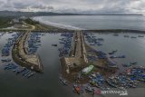 Foto udara sejumlah kapal nelayan bersandar di Pelabuhan Perikanan Cikidang, Kabupaten Pangandaran, Jawa Barat, Rabu (8/1/2020). Sebagian nelayan di daerah tersebut memilih tidak melaut akibat cuaca buruk dan tingginya ombak dalam sepekan terakhir, sehingga beralih profesi menjadi pemandu wisata serta jasa sewa perahu wisata. ANTARA JABAR/Adeng Bustomi/agr