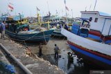 Nelayan memperbaiki perahu saat tidak melaut di Pelabuhan Branta Pesisir, Pamekasan, Jawa Timur, Jumat (10/1/2020). Dalam beberapa hari terakhir sejumlah nelayan di daerah itu, tidak melaut karena cuaca ekstrim. Antara Jatim/Saiful Bahri/zk